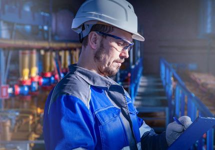 Industrie-Mitarbeiter mit Arbeitskleidung (Helm, Handschuhe, Blaumann)